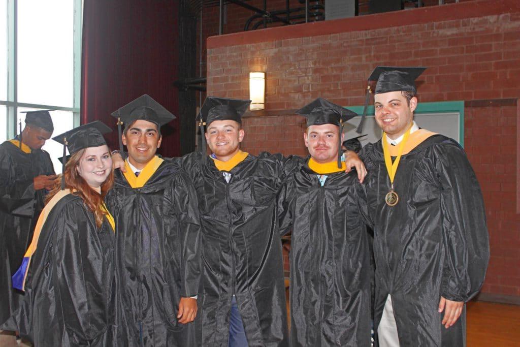 学生们在毕业前聚集在一起，头戴帽子，身穿长袍.